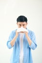 Young asian man sneezing after get allergy or flu virus and using tissue paper for swipe on nose at medical clinic after got Royalty Free Stock Photo