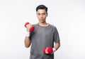 Young asian man in sport outfits exercising with dumbbells and looking to camera isolated on white background. Royalty Free Stock Photo