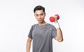 Young asian man in sport outfits exercising with dumbbells and looking to camera isolated on white background. Royalty Free Stock Photo