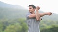 Young asian man in sportswear stretching his arm, warming up before morning workout at outdoors. Healthy lifestyle Royalty Free Stock Photo