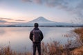 Young asian man stand looking Mount Fuji on Kawaguchiko Lake at