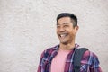 Young Asian man standing on a city street laughing Royalty Free Stock Photo