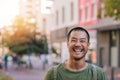 Young Asian man standing on a city street laughing Royalty Free Stock Photo