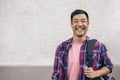 Young Asian man standing outside in the city and laughing Royalty Free Stock Photo