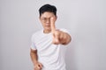 Young asian man standing over white background pointing with finger up and angry expression, showing no gesture Royalty Free Stock Photo