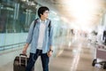 Young Asian man with suitcase luggage in airport terminal Royalty Free Stock Photo