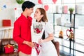 A young Asian man surprised his girlfriend by giving her a rose and flower bouquet for her anniversary date at home. Royalty Free Stock Photo