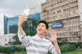 Young Asian man taking selfie on the background of city