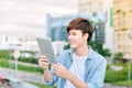 Young asian man tourist using digita; tablet outdoor in the city