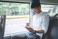 Young Asian man traveler sitting on a bus using tablet watch video or playing game while smile of happy, transport, tourism and Royalty Free Stock Photo