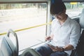 Young Asian man traveler sitting on a bus using tablet watch video or playing game while smile of happy, transport, tourism and Royalty Free Stock Photo