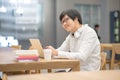 Young Asian man university student doing homework Royalty Free Stock Photo