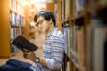 Young Asian man university student reading book in library Royalty Free Stock Photo