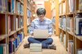 Young Asian man student using laptop in library Royalty Free Stock Photo