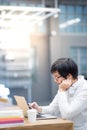 Young Asian man university student using smartphone in library Royalty Free Stock Photo