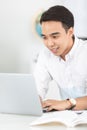 Young Asian man university student working with laptop computer. Royalty Free Stock Photo