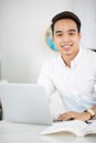 Young Asian man university student working with laptop computer. Royalty Free Stock Photo