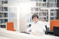 Young Asian man university student working in library Royalty Free Stock Photo