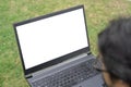 Young asian man using laptop with isolate screen while sitting on grass at park. Man using laptop for online Royalty Free Stock Photo