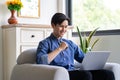 Young asian man using laptop in living room Royalty Free Stock Photo