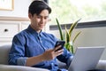 Young asian man is using the phone while using the computer Royalty Free Stock Photo