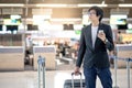 Young asian man using smartphone in airport terminal Royalty Free Stock Photo