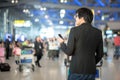 Young asian man using smartphone in airport terminal Royalty Free Stock Photo