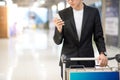 Young asian man using smartphone in airport terminal Royalty Free Stock Photo