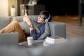 Young Asian man using smartphone relaxing on sofa Royalty Free Stock Photo