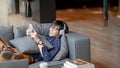 Young Asian man using smartphone relaxing on sofa Royalty Free Stock Photo