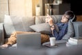 Young Asian man using smartphone relaxing on sofa Royalty Free Stock Photo