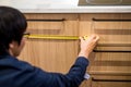 Young Asian man using tape measure for measuring furniture Royalty Free Stock Photo