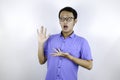 Young asian man war blue shirt is surprised and shouting wow with pointing right with his finger  on gray background Royalty Free Stock Photo