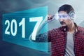 Young asian man wear VR headset looking into 2017 number