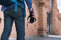 young asian man wearing blue shirt and jeans with camera and backpack standing near old brick wall Royalty Free Stock Photo