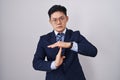 Young asian man wearing business suit and tie doing time out gesture with hands, frustrated and serious face Royalty Free Stock Photo