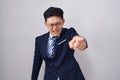 Young asian man wearing business suit and tie pointing displeased and frustrated to the camera, angry and furious with you Royalty Free Stock Photo