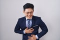 Young asian man wearing business suit and tie smiling and laughing hard out loud because funny crazy joke with hands on body Royalty Free Stock Photo