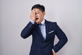 Young asian man wearing business suit and tie yawning tired covering half face, eye and mouth with hand Royalty Free Stock Photo