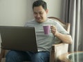 Young Man Working at Home on His Laptop, Smiling Expression Royalty Free Stock Photo