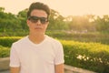 Young Asian man wearing sunglasses while relaxing at the park Royalty Free Stock Photo