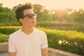 Young Asian man wearing sunglasses while relaxing at the park Royalty Free Stock Photo