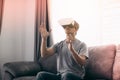 Young asian man wearing virtual reality glasses at living room for admiring virtual reality Royalty Free Stock Photo