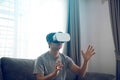 Young asian man wearing virtual reality glasses at living room for admiring virtual reality Royalty Free Stock Photo