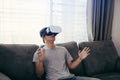 Young asian man wearing virtual reality glasses at living room for admiring virtual reality Royalty Free Stock Photo