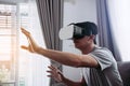 Young asian man wearing virtual reality glasses at living room for admiring virtual reality Royalty Free Stock Photo