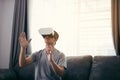 Young asian man wearing virtual reality glasses at living room for admiring virtual reality Royalty Free Stock Photo