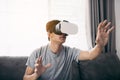 Young asian man wearing virtual reality glasses at living room for admiring virtual reality Royalty Free Stock Photo