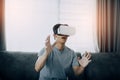 Young asian man wearing virtual reality glasses at living room for admiring virtual reality Royalty Free Stock Photo