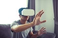 Young asian man wearing virtual reality glasses at living room for admiring virtual reality Royalty Free Stock Photo